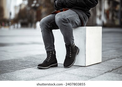 A pair of dark brown leather boots and grey denim jeans make a stylish statement in this urban fashion photo. - Powered by Shutterstock