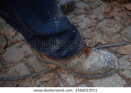 Similar – Foto Bild ausgelatschte Arbeitsschuhe mit Straßenbesen und Schaufel auf Kopfsteinpflaster