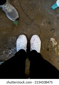 A Pair Of Dirty White Shoes Covered In Mud And Dirt.