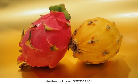 Pair Of Dragon Fruit In Front Of Gold