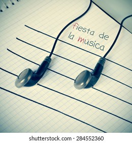 A Pair Of Earphones Placed On A Staff Drawn On A Notepad Simulating Musical Notes, And The Text Fiesta De La Musica, World Music Day Written In Spanish