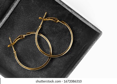 Pair of elegant gold earrings in jewel box closeup