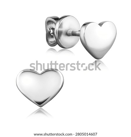 A pair of elegant sterling silver stud earrings in a sleek heart shape with a polished finish. The romantic jewelry is isolated on a white background with a soft reflection.                               