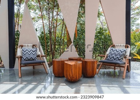 Pair of empty chairs and wooden table at the garden of luxury hotel resort in Costa Rica. Travel and vacation concept