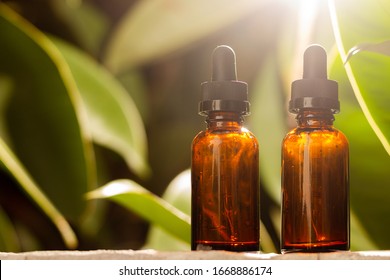 Pair of empty droppers in the foreground in front of nature background. healthy concept. medicine containers. bottles for essential oils