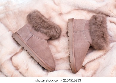 un par de botas de cerdo de invierno de moda sobre fondo de piel, nuevo par