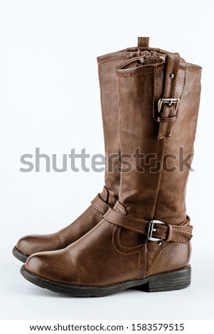 Pair of female brown cowboy style boots on white background