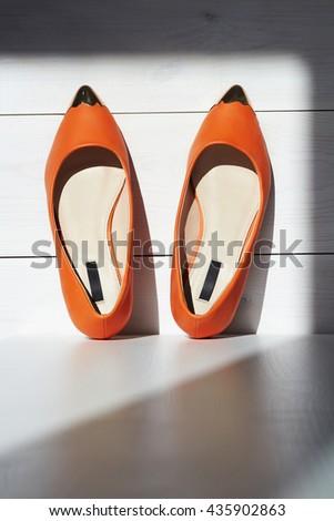 Pair of female summer shoe on wooden background.orange girls shoes without heels