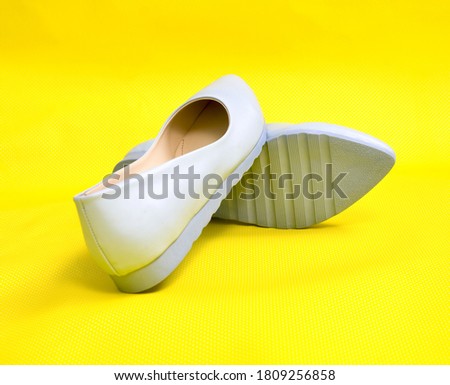 Pair of female summer shoes  on yellow background image,