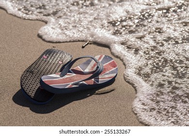 A pair of flip flop sitting on the beach during a sunset / Beach thongs