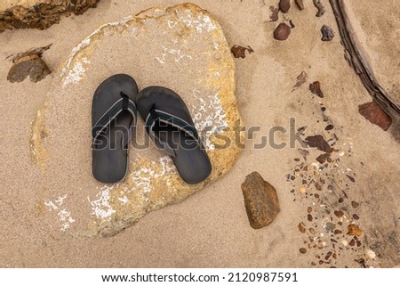 pair of flip flops on a rock beach 