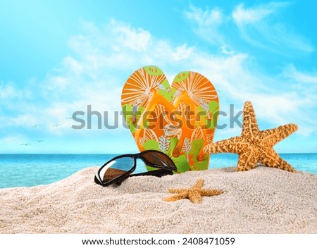 Pair of flip- flops in the sand with starfish