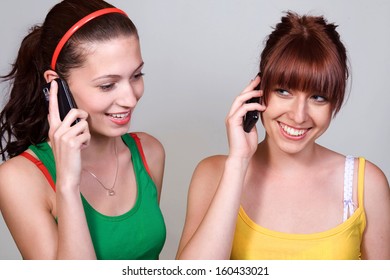 A Pair Of Girls On The Phone Together. Teenage Friends Are Calling From A Mobile Phone.