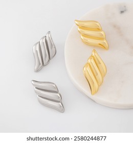 A pair of gold and silver earrings in the shape of hearts. Jewelry catalog.
