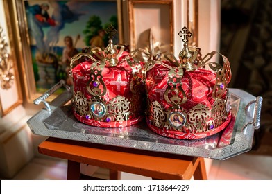pair of golden crowns on the silver server in the church