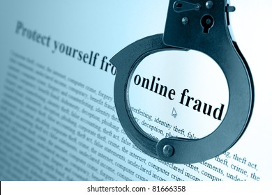 Pair Of Handcuffs Frame The Words Online Fraud On A Computer Monitor