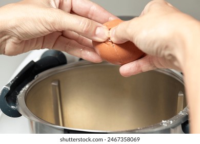 pair of hands cracking an egg into a pot of boiling water, likely for poaching