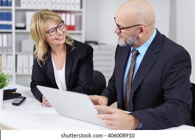 Pair Of Happy Male And Female Business Executives Wearing Suit Jackets Discussing Something On Calendar In Small Office