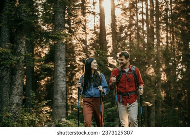 A pair of hikers, geared up and ready for action, pause for a moment to take in the breathtaking vistas of a remote mountain forest - Powered by Shutterstock