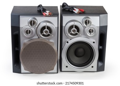 Pair of home high fidelity three-way loudspeaker systems with bass reflex port in black wooden housing and analog audio cables with coaxial connectors on a white background