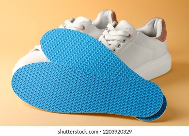 Pair Of Insoles And Shoes On Pale Orange Background