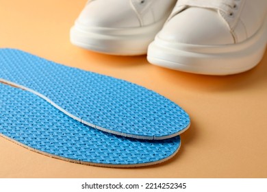 Pair Of Insoles And Shoes On Pale Orange Background