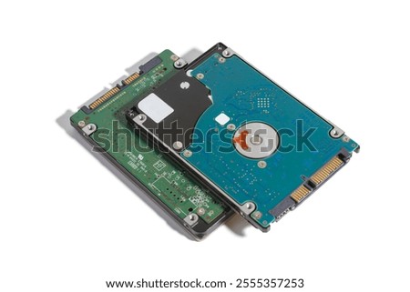 A pair of internal notebook 2.5 inch SATA hard disk drives. The drives are positioned against on white background. One drive reveals its internal components, showcasing the circuit board and plat