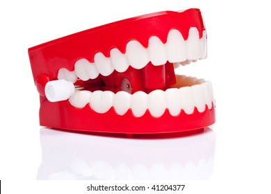 A pair of joke wind up chattering teeth on a pure white background, high resolution photo.