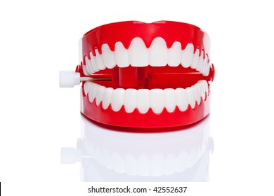 A pair of joke wind up chattering teeth on a pure white background, high resolution photo.