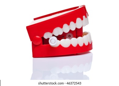 A pair of joke wind up chattering teeth on a pure white background.