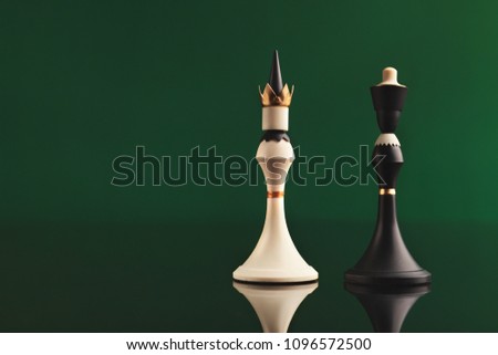 Pair of king chess pieces confronted as opposites on green background with reflection. Forbidden love, rival figures, copy space