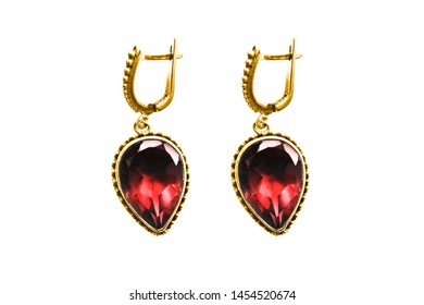 Pair of large red ruby gold earrings isolated over white