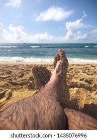 Pair Of Legs Crossed On Beach