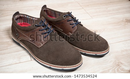 Pair of male brown suede shoes on the wooden background