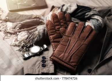 Pair of men's brown leather gloves and other men's accessories. - Powered by Shutterstock