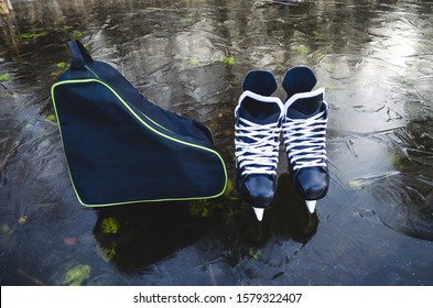 A Pair Of Men's Hockey Skates Stand On The Lake And A Bag For Carrying Skates.