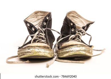 Pair Of Men's Or Teenager's Grundy Worn Out Dirty High Top Athletic Tennis Shoes With Long Laces Isolated On White Background