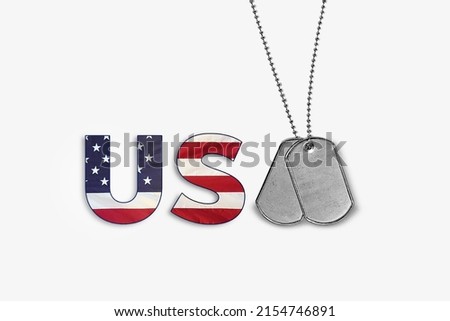 Pair of military dog tags with United States flag symbol creating USA text concept on white