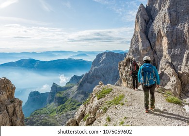 Pair of mountaineers walking a mountain path.