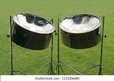 A Pair Of Musical Metal Steel Drums On Stands.