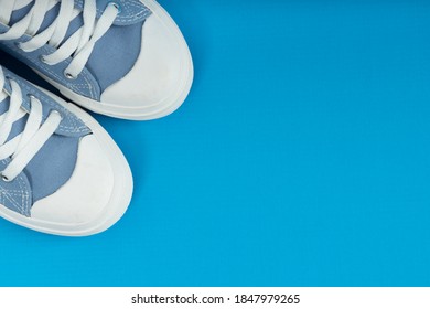 Pair Of New Blue Sneakers, Sport Shoes On Blue Background. Top Down View