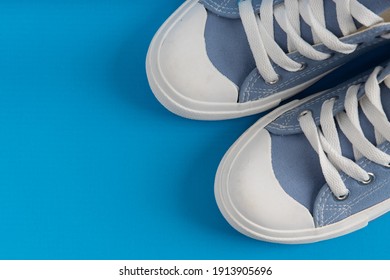 Pair Of New Blue Sneakers, Sport Shoes On Blue Background. Top Down View