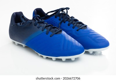Pair of new football cleats with studs on outsole designed for playing on grass pitches isolated on white. Special modern sports shoes concept