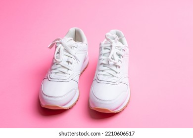 Pair Of New White Sneakers Over Pink Seamless Background. Horizontal Image