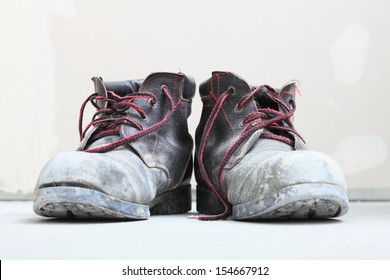 Pair Of Old Dirty Work Boots In Construction Site