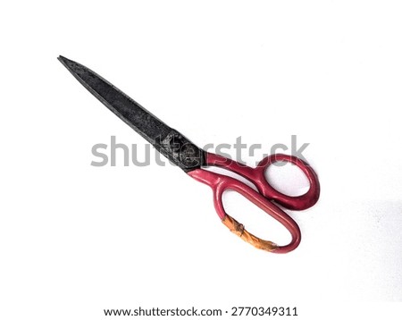 A pair of old and rusty red-handled scissors on white background