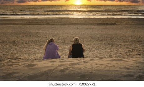 Pair on the beach at sunset