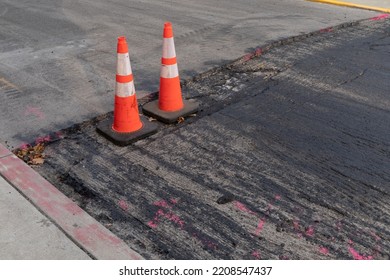 Pair Of Orange Traffic Cones And Bright Pink Paint Mark The Edges Of A Milled Asphalt Road Patch, Horizontal Aspect