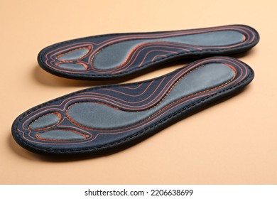 Pair Of Orthopedic Insoles On Pale Orange Background