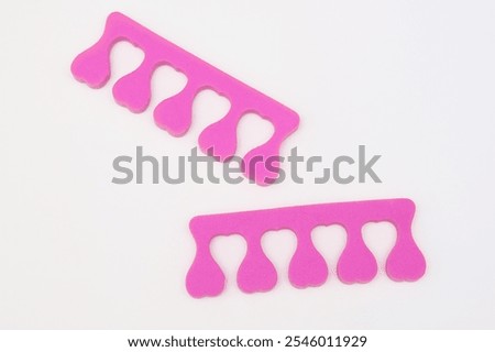 A pair of pink toe separator on white background, pedicure concept